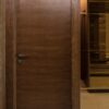درب اتاق میلان، درب قهوه‌ای تیره کنار قفسه
