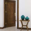 درب اتاق ورشو، درب قهوه‌ای باز کنار میز و گلدان آبی