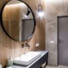 کابینت روشویی راین، روشویی مشکی و آینه گرد کنار دیوار چوبی